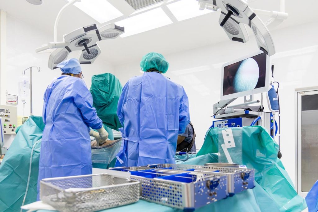 Team of surgical professionals performs endoscopic spine surgery on patient